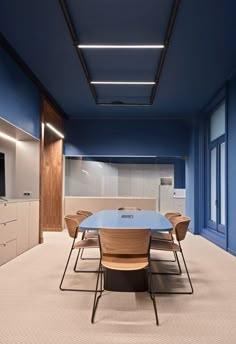 an empty conference room with blue walls and white carpeted flooring is pictured in this image