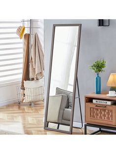 a large mirror sitting on top of a wooden table next to a lamp and chair