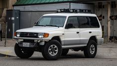 a white suv parked in front of a building