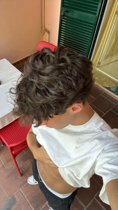 a young boy sitting at a table with a laptop computer on it's lap