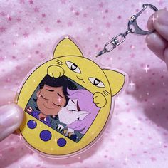 a person holding a keychain with an image of cartoon characters on the front