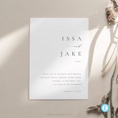 a white wedding card with the word, issa and jake on it next to dried flowers