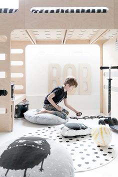 a young boy sitting on top of a bean bag chair in a room filled with furniture