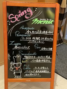 a menu board with writing on it in front of a store display case and carpeted floor