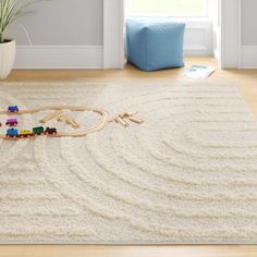 a child's toy train set sitting on top of a rug in a living room