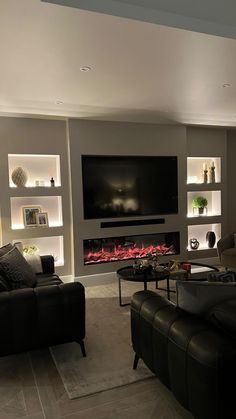 a living room filled with furniture and a flat screen tv mounted on the wall above a fire place