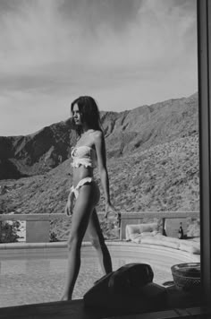 a woman in a bathing suit standing by a pool