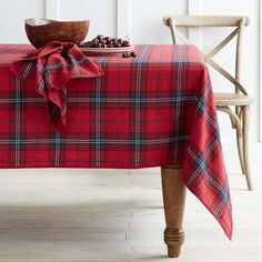 a table with a red plaid cloth on it and a wooden bowl sitting next to it