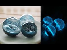 three different types of blue and white marbles on a plate, one is black and the other is light blue