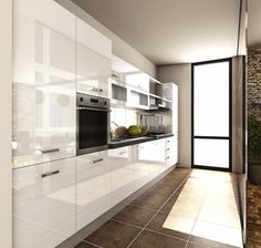 a modern kitchen with white cabinets and black counter tops, along with an open door leading to the outside patio