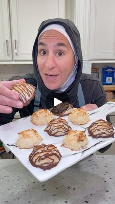 a person holding a tray with some cookies on it