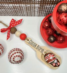 some red and white ornaments are sitting on a table next to a bowl full of chocolates