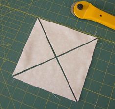 a pair of scissors sitting on top of a piece of paper next to an origami block