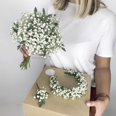 a woman holding a bouquet of flowers in her hand and a brown box with it