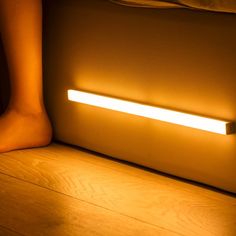 a person standing next to a bed with a light on it