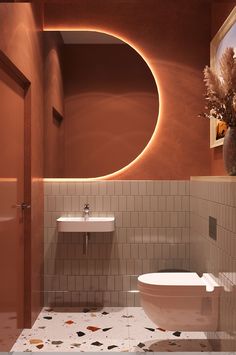 a bathroom with a toilet, sink and mirror on the wall next to tiled walls