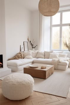 a living room filled with furniture and a fire place in front of a large window