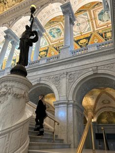 there is a statue on top of the stairs in this building and it's painted