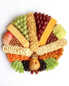 a platter filled with cheese, crackers, grapes, apples and other foods