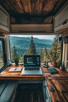 an open laptop computer sitting on top of a wooden desk in front of a window