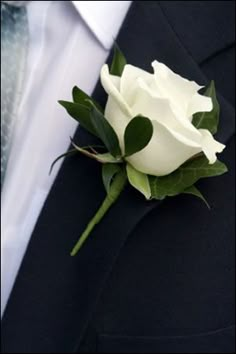 a boutonniere with white flowers and green leaves