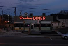 a restaurant with neon sign on the side of it