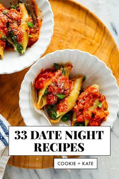 three white bowls filled with pasta and sauce on top of a wooden cutting board next to a