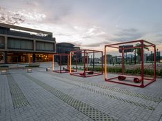 three metal structures sitting in the middle of a courtyard