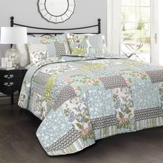 a bed with a blue and green quilt on it