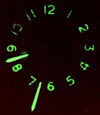 a close up of a clock with green numbers on it