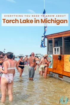 many people are standing in the water near a food truck that says, everything you need to know about torch lake in michigan