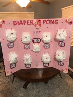 a pink sign with diapers on it in front of a wall that says diaper pong