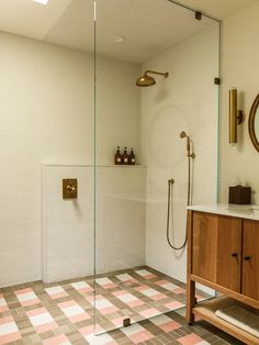 a bathroom with a shower, sink and mirror in it's corner area on the tiled floor