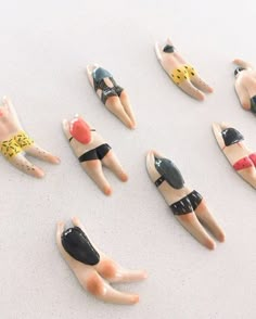 there are many small figurines laying on top of each other in the shape of people