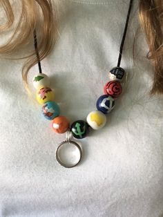 a woman wearing a white shirt and a necklace with colorful beads hanging from it's neck