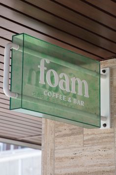 a foam coffee and bar sign hanging from the side of a wooden building with wood slats