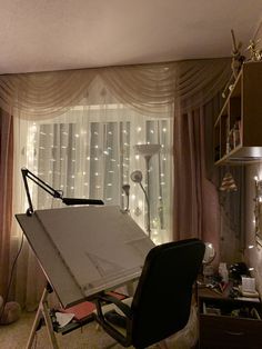 an artist's easel sitting in front of a window with lights on it