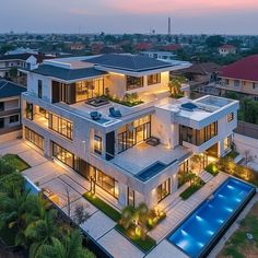 an aerial view of a modern house with pool in the foreground and surrounding buildings