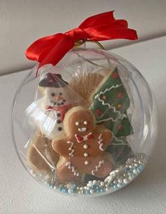 a glass ornament filled with cookies and decorations