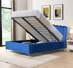 a blue bed frame with a mattress underneath it in a room next to a window