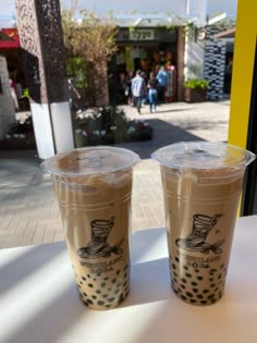 two plastic cups sitting on top of a table