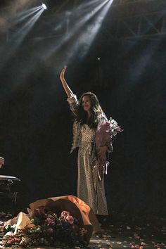 a woman standing in front of a piano on stage