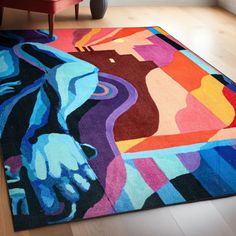 a colorful area rug on the floor in a room with hardwood floors and furniture,