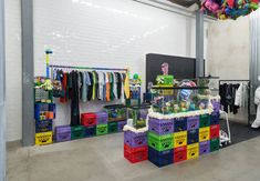 a room filled with lots of colorful baskets and clothes hanging on the wall next to each other