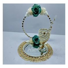 a necklace with flowers and pearls on it is sitting on top of a table next to a mirror