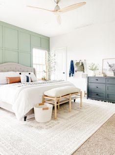 a bedroom with a bed, dresser and ceiling fan