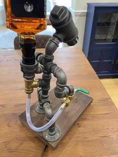 a wooden table topped with a metal pipe holder and a glass bottle on top of it