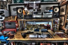 a room filled with lots of different types of musical instruments and sound equipment on top of a wooden table