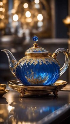 a blue tea pot sitting on top of a gold plate