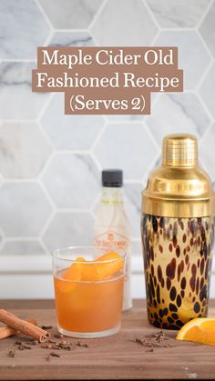 an orange and cinnamon drink sitting on top of a wooden table next to a shaker